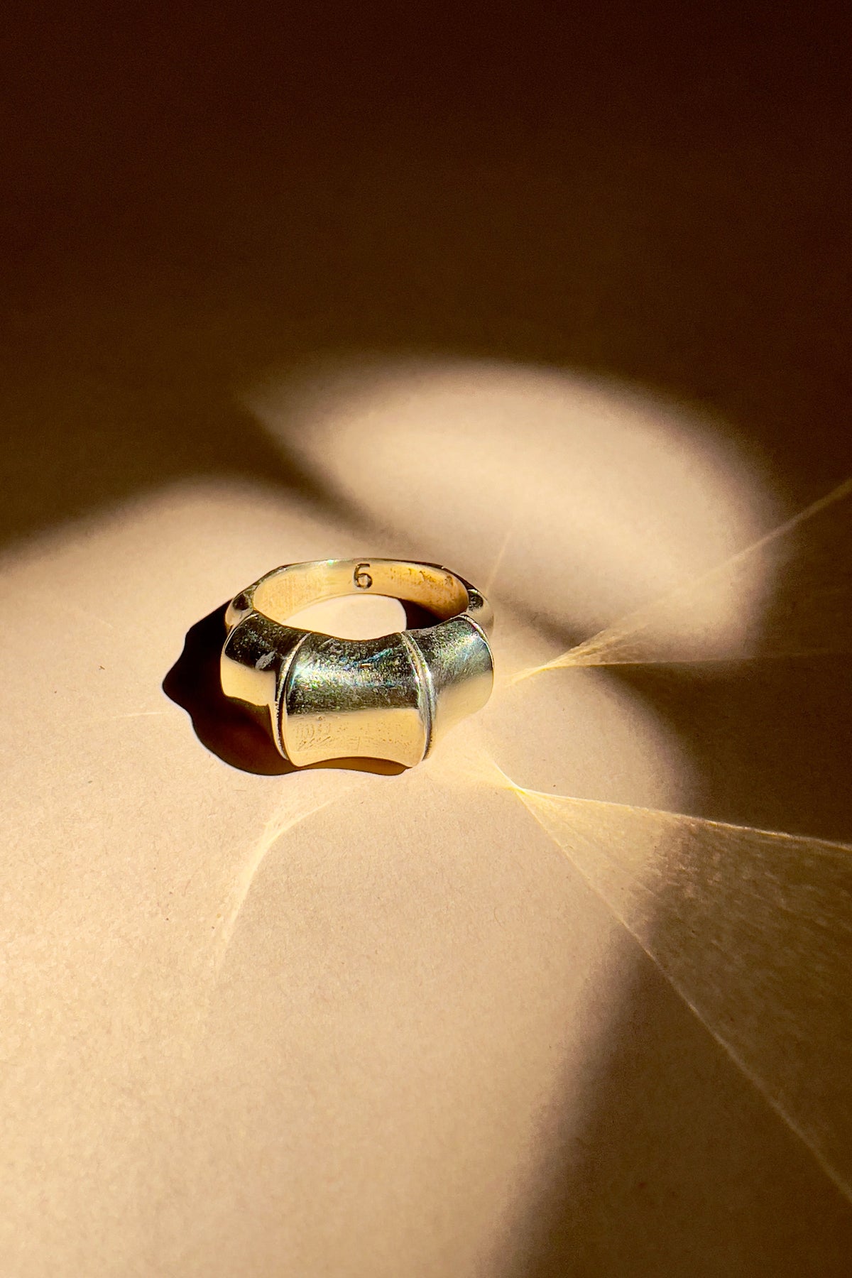 Gold ring on a textured surface with light casting shadows