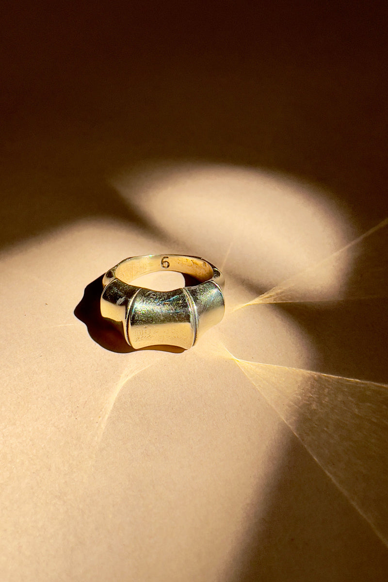 Gold ring on a textured surface with light casting shadows